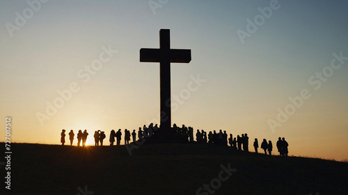 Hands to the sky, group of people with hands up looking at the sunset, at the foot of the cross photo