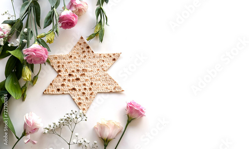 Passover. banner of Traditional Matzo shape of star Magen David  decorate by pink flowers on white background. top view. Holiday of Jewish people, Spring Holiday. Fasting time photo