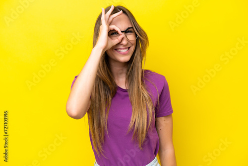 Young caucasian woman isolated on yellow background With glasses with happy expression