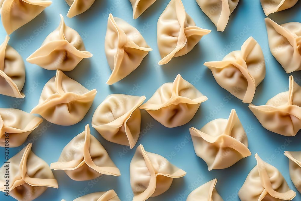 Arranged dumplings on blue background, poised for cooking. Arranged dumplings on blue background, poised for cooking.