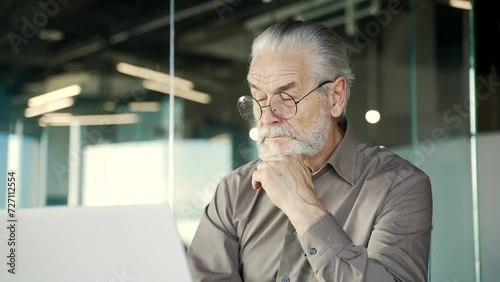 Wallpaper Mural Thoughtful senior gray haired businessman thinking about problem solving sitting at laptop at workplace in business office. Mature entrepreneur owner in glasses is busy with a project on the computer Torontodigital.ca