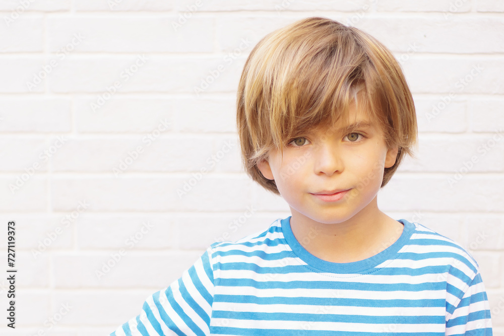 Frontal portrait of a 9-year-old blond-haired green-eyed boy looking at the camera with neutral expression. Isolated on white background. Frontal portrait of a 9-year-old blond-haired green-eyed boy looking at the camera with neutral expression. Isolated on white background.