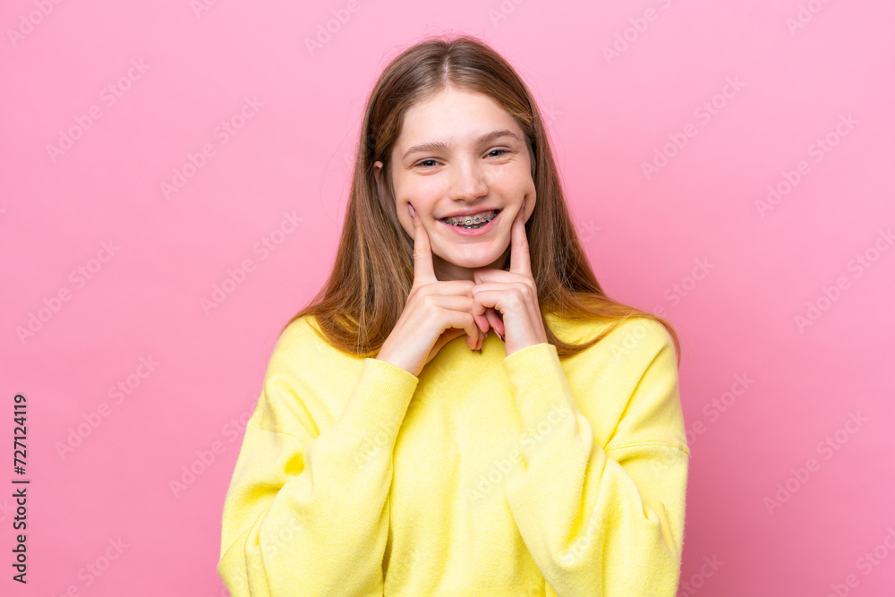 Teenager Russian girl isolated on pink background smiling with a happy and pleasant expression Teenager Russian girl isolated on pink background smiling with a happy and pleasant expression