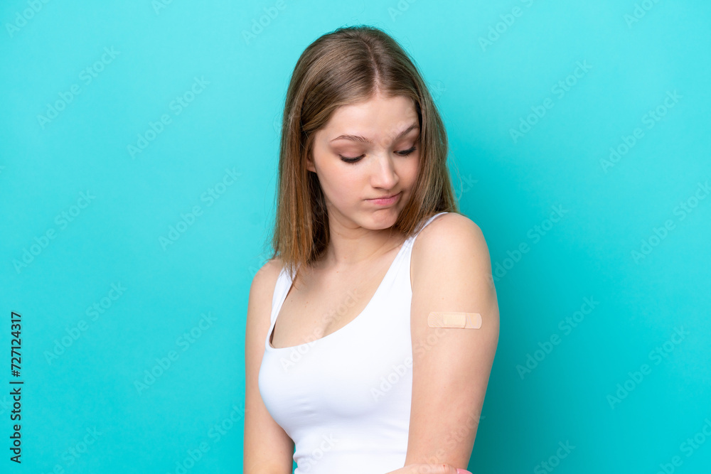 Teenager Russian girl wearing a band aids isolated on blue background with sad expression Teenager Russian girl wearing a band aids isolated on blue background with sad expression