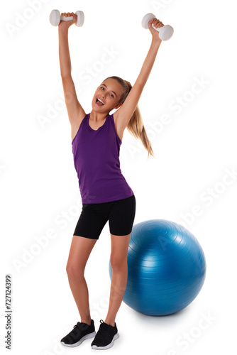Slim and fit teen girl holding a dumbbells with arms up. Swiss blue ball on background. Full length shot on white