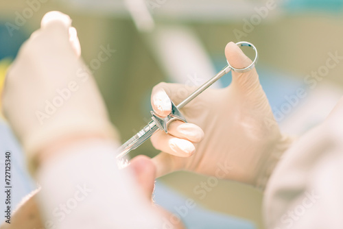 Detail of a dentist performing surgery with anesthesia on a patient for root canal treatment and regeneration. No people are recognizable.