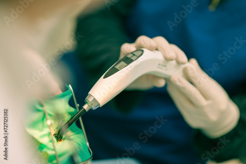 Detail of a dentist performing surgery with anestethics on a patient for root canal treatment and regeneration. No people are recognizable.