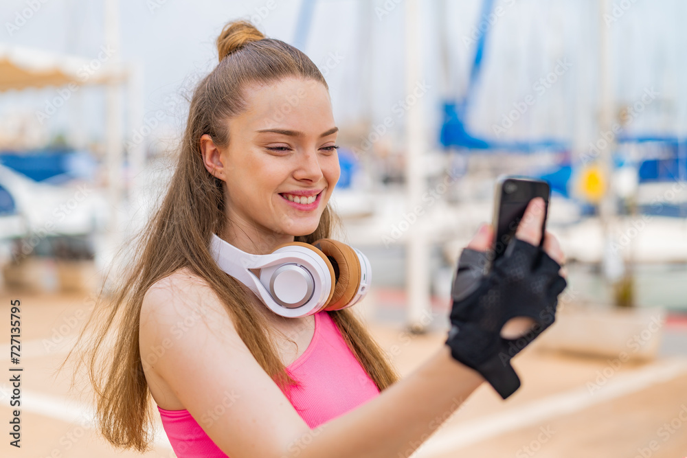 Young pretty sport girl at outdoors making a selfie with mobile phone Young pretty sport girl at outdoors making a selfie with mobile phone