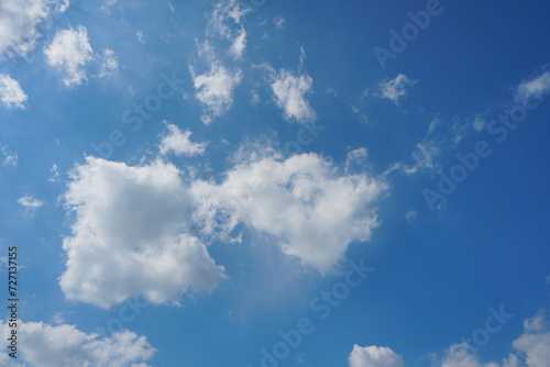 White fluffy clouds in the sky. Blue sky and cloud cover on a sunny summer day. Empty background  copy space