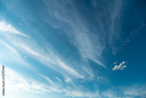 White fluffy clouds in the sky. Blue sky and cloud cover on a sunny summer day. Empty background, copy space #727137961