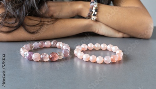 two bracelets made of natural pink quartz stones beads isolated on gray background handmade jewelry woman exoteric accessories talismans and amulets selective focus photo
