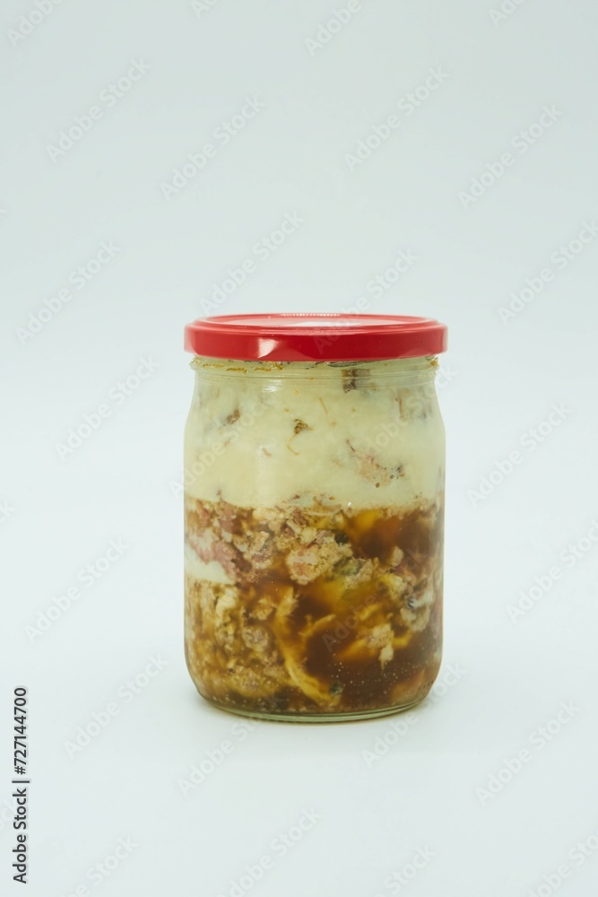 Stewed meat in a glass jar, canned. The product is ready to use. White background. Stewed meat in a glass jar, canned. The product is ready to use. White background.
