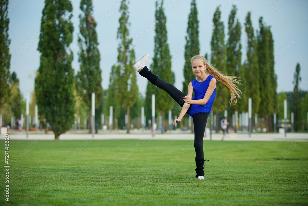 Girl gymnast school age in a suit shows the elements of the sport. Girl gymnast school age in a suit shows the elements of the sport.