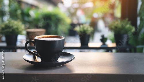 a black cup of hot coffee on table in cafe