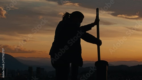Man in Silhouette Cleans Cannon Barrel at Sunset. Concept of Ramadan Tradition in Sarajevo, Chimney Sweep photo