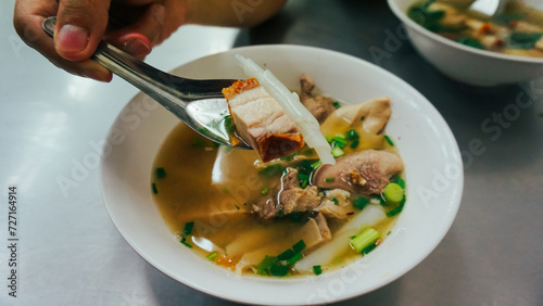 Thai peppery soup and crispy pork, called Kuay Jab clear soup. Noodle roll soup, like a traditional Thai style breakfast but come from China. photo