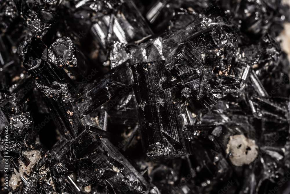 Tourmaline black crystals. Gems. Mineral crystals in the natural environment. Texture of precious and semiprecious stones. Seamless background with copy space colored shiny surface of precious stones.