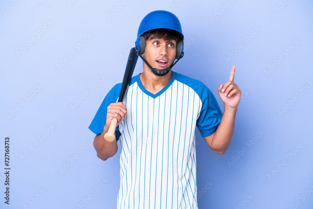 Baseball caucasian man player with helmet and bat isolated on blue background thinking an idea pointing the finger up Baseball caucasian man player with helmet and bat isolated on blue background thinking an idea pointing the finger up