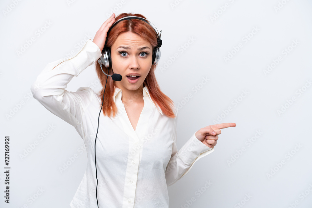 Telemarketer Russian girl working with a headset isolated on white background surprised and pointing finger to the side Telemarketer Russian girl working with a headset isolated on white background surprised and pointing finger to the side