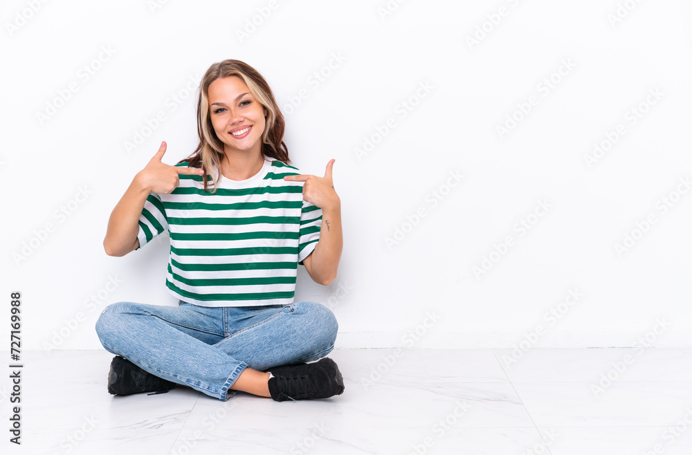 Young Russian girl sitting on the floor isolated on white background proud and self-satisfied Young Russian girl sitting on the floor isolated on white background proud and self-satisfied