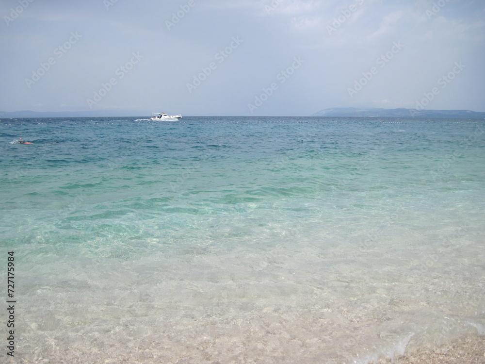 Obraz premium Scenic shining view of the clear water of Adriatic Sea on a sunny summer day. Colorful natural fresh background for creative illustration with shiny blur effect. Bright nautical scape beauty closeup