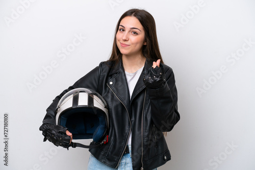 Young girl with a motorcycle helmet isolated on white background making money gesture