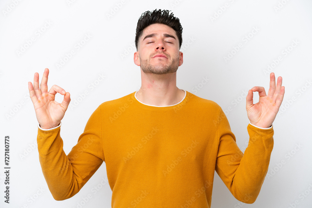 Young caucasian man isolated on white background in zen pose