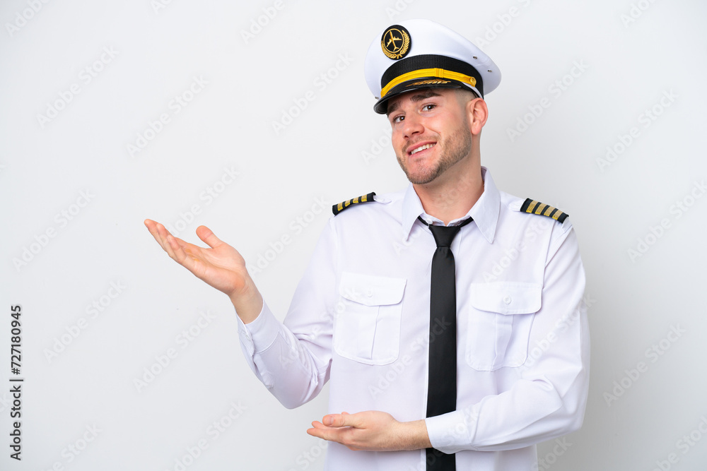 Airplane caucasian pilot isolated on white background extending hands to the side for inviting to come