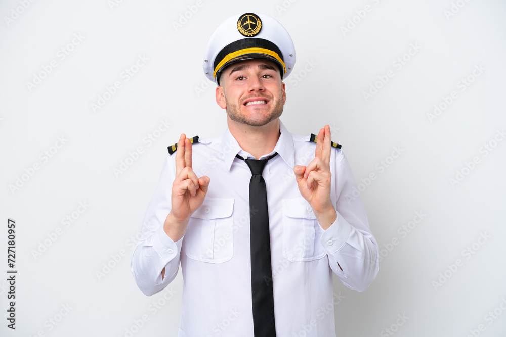 Airplane caucasian pilot isolated on white background with fingers crossing Airplane caucasian pilot isolated on white background with fingers crossing