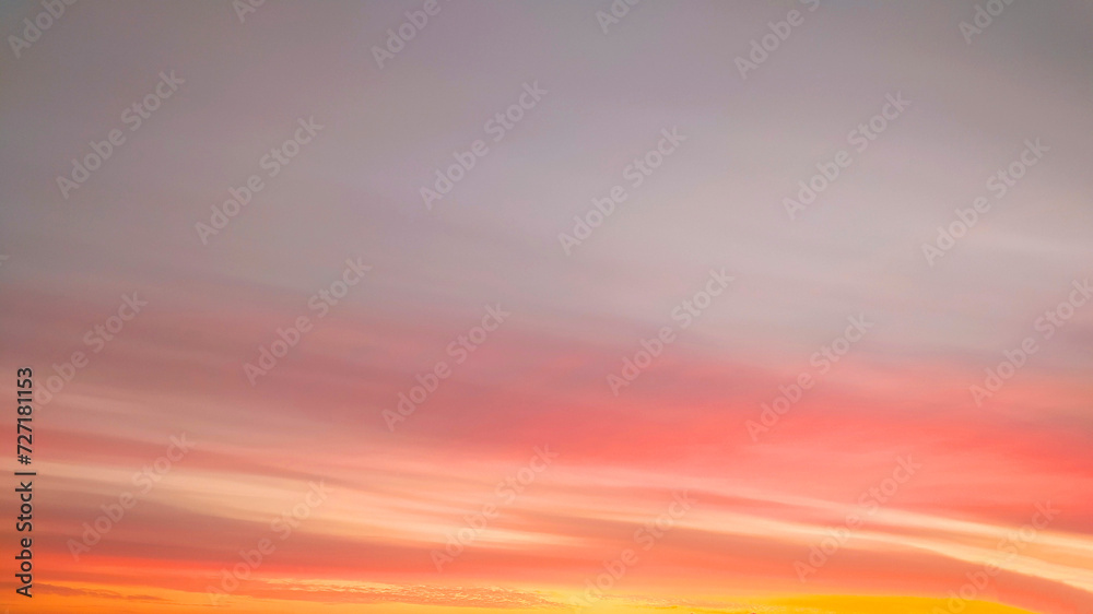 Panorama of the yellow sky with fancy clouds at sunset.