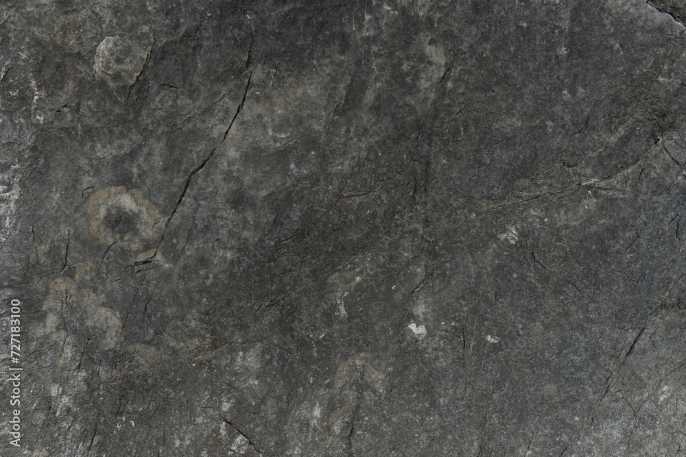 Naklejka premium Stone floor has a unique rough surface and dark color. For background and textured.