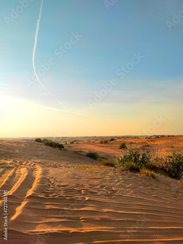 Desert landscape with traces of tyres and boots on the sand. Dubai desert. Nature background with copy space