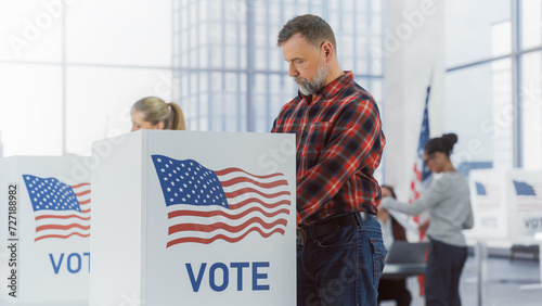 Democratic Process on Elections Day in the United States of America: Masculine Cowboy in Jeans and Checkered Shirt Casting His Vote in Private in Voting Booth and Putting His Ballot into a Sealed Box photo