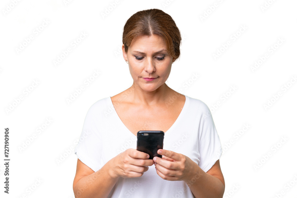 Middle-aged caucasian woman over isolated background using mobile phone Middle-aged caucasian woman over isolated background using mobile phone