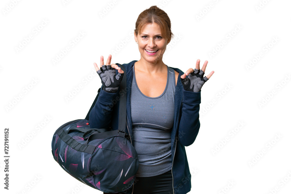 Middle-aged sport woman with sport bag over isolated background showing an ok sign with fingers Middle-aged sport woman with sport bag over isolated background showing an ok sign with fingers