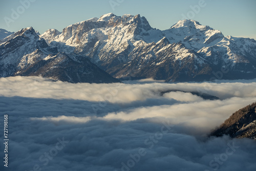 Mountain above clouds, Civetta resort. Panoramic view of the Dolomites mountains in winter, Italy. Ski resort in Dolomites, Italy. Aerial  drone view of ski slopes and mountains in alps.