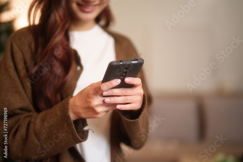 Happiness young asian women using technology on smartphone to surfing social media and entertainment for relaxation time while working about new business startup project in living room at home office