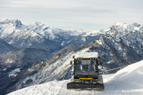 Piste groomer in front of the Mountains Dolomites alps  Italy. Snow groomer in dolomites alps in Italy. snow groomer in winter mountains.