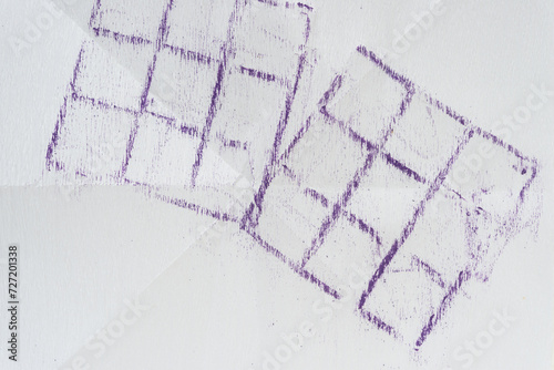 two purple oil pastel grids (rubbings) on paper with crease lines photo
