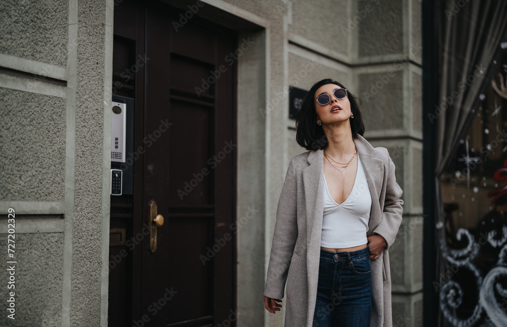 Fashionable young girl in a chic autumn outfit enjoying a city walk.