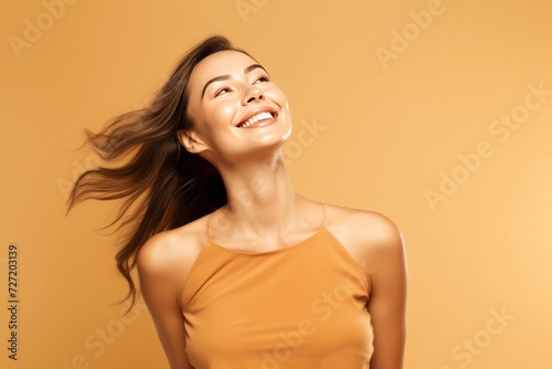 Vibrant Joy Portrait of the vibrant joy of a young woman, her smiling pose radiating happiness against a bright wall orange background. Generative AI.