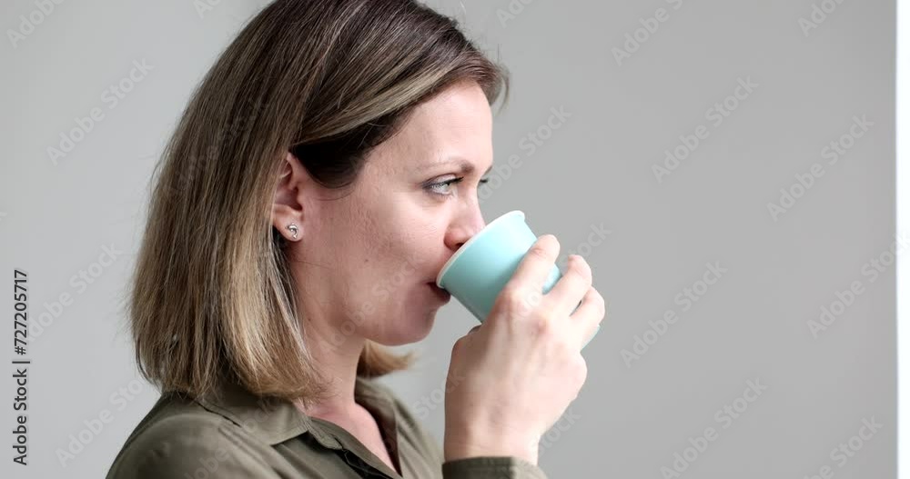 Beautiful girl at work drinks water or coffee from paper cup. Periodic replenishment of body moisture Beautiful girl at work drinks water or coffee from paper cup. Periodic replenishment of body moisture