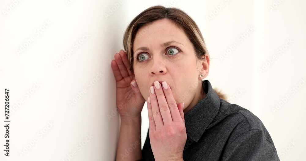 Portrait of woman eavesdropping on private conversations behind wall. Manager spying and eavesdropping through wall with shocked expression Portrait of woman eavesdropping on private conversations behind wall. Manager spying and eavesdropping through wall with shocked expression