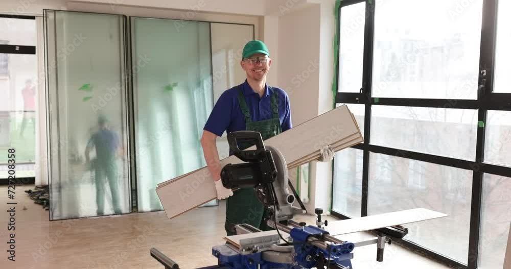 Male builder holds laminated board in hands in office. Services for repair and decoration of apartments and houses and laying flooring