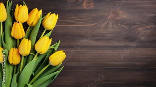yellow tulips on wooden background, top view, spring bouquet