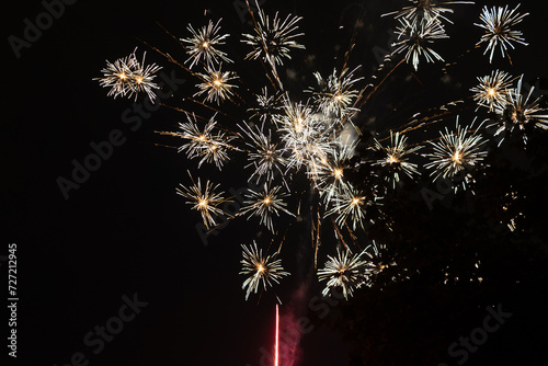 Bursts of white and yellow fireworks at night - vibrant streaks and sparks - smoke clouds - celebration  new years day  fourth of july  canada day. Taken in Toronto  Canada.