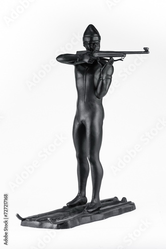 A purchased (consumer) biathlete figurine made of cast iron in close-up on a white background