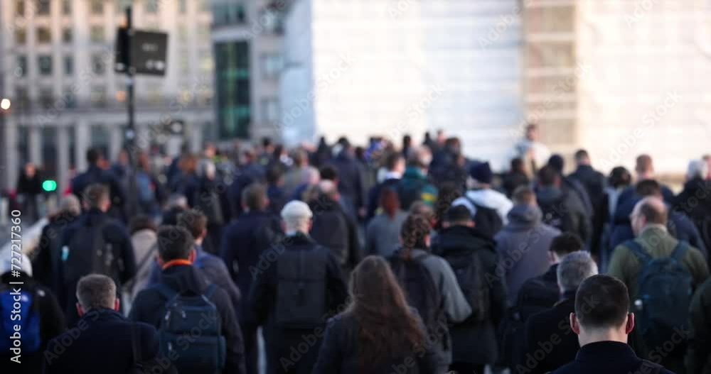 Slow motion shallow focus view of a large crowd of commuters going to work in the City during morning time, London, England
