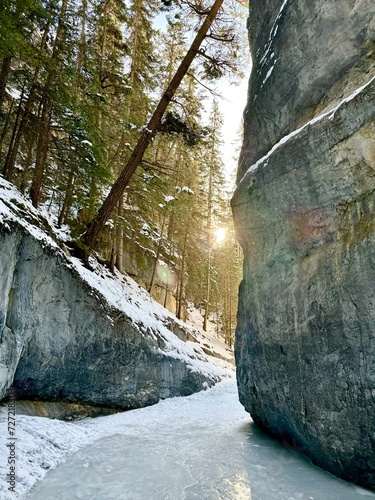 Sun appearing in the Grotto Canyon on an icy floor in Canmore, Alberta photo