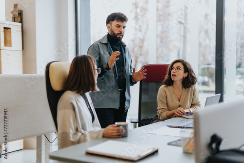 Company coworkers discussing reports, planning costs, and strategizing for profit growth and project development in a creative office. photo